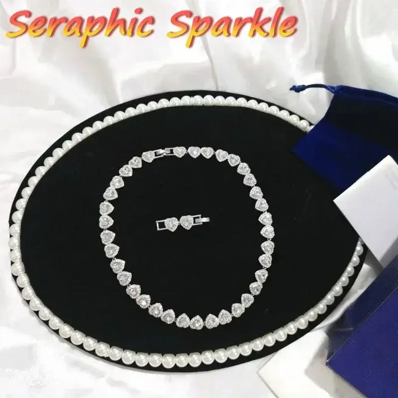 Silver heart-shaped sterling silver tennis necklace and matching bracelet set adorned with sparkling crystals