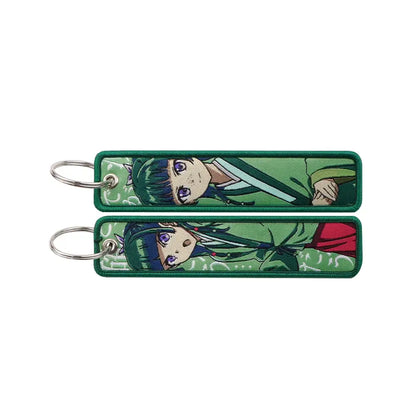 Green embroidered metal apothecary diaries maomao keychain with purple eyes and dark green hair key ring design