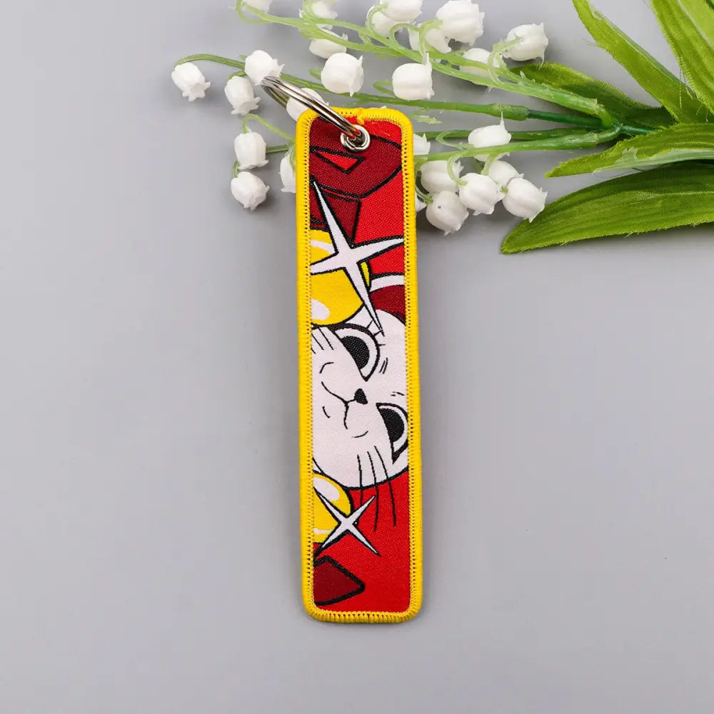 Apothecary diaries maomao keychain with vibrant red and yellow embroidered cartoon cat design and metal key ring