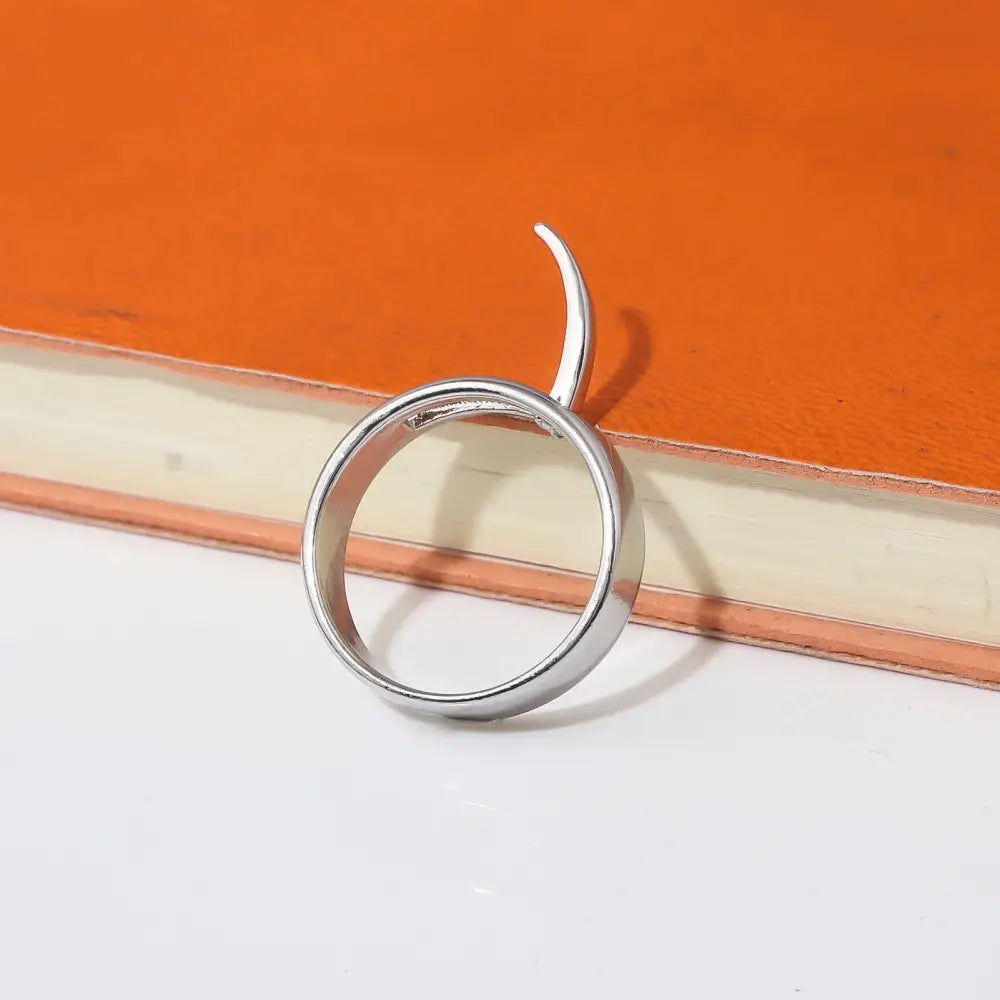 Silver ring featuring a single curved horn-like protrusion inspired by annie leonhart transformation style