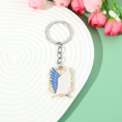 Metallic enamel pin keychain with a blue and white scout regiment winged emblem on a gold-toned shield pendant