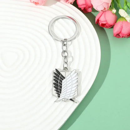 Silver metal enamel pin keychain featuring the scout regiment emblem with black and white detailing from attack on titan