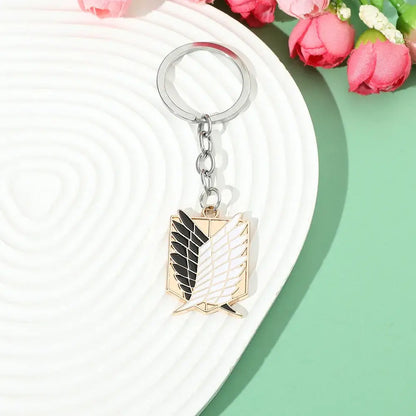 Silver and gold enamel pin keychain featuring attack on titan scout regiment emblem for fans and collectors