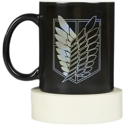 Black ceramic color change mug featuring a white-outlined iridescent attack on titan wings of freedom emblem