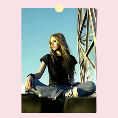 Avril lavigne wall poster featuring a woman with long blonde hair sitting cross-legged in blue jeans against clear sky