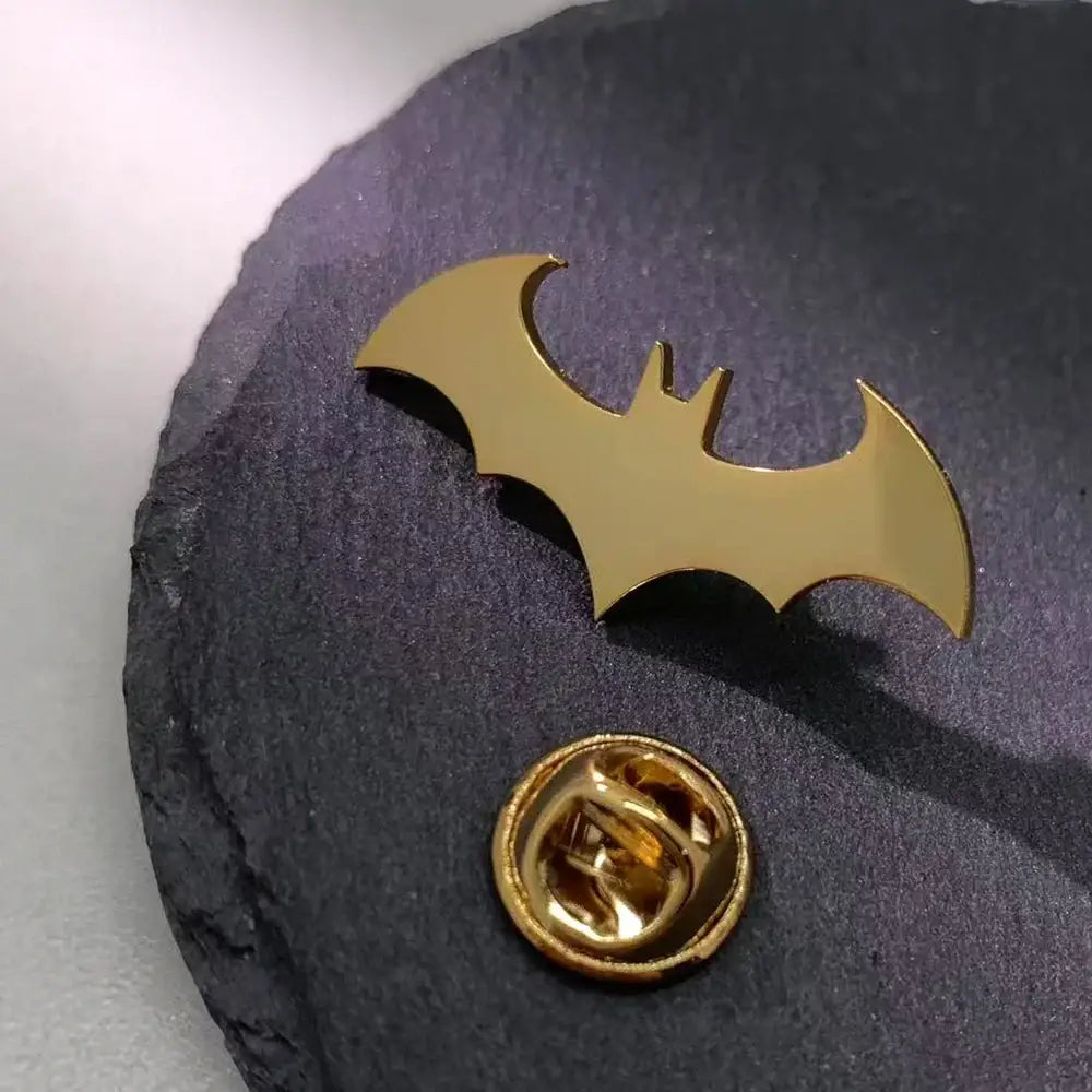 Gold-colored stainless steel batman symbol lapel pin with a polished finish and classic bat silhouette design