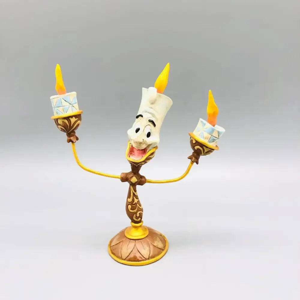 Beauty and the beast cogsworth clock figure with golden brown lumia candle holder featuring two lit candles and smiling face