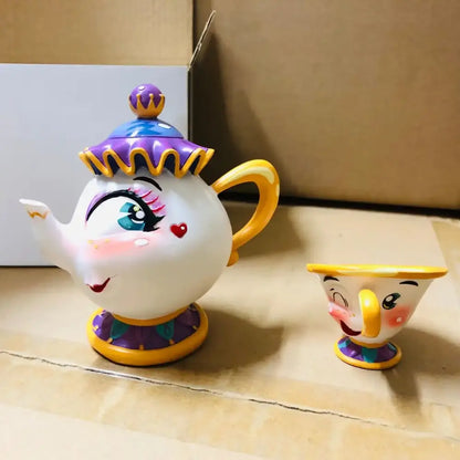 A white ceramic beauty and the beast cogsworth clock jewelry box teapot and cup with yellow accents and whimsical design