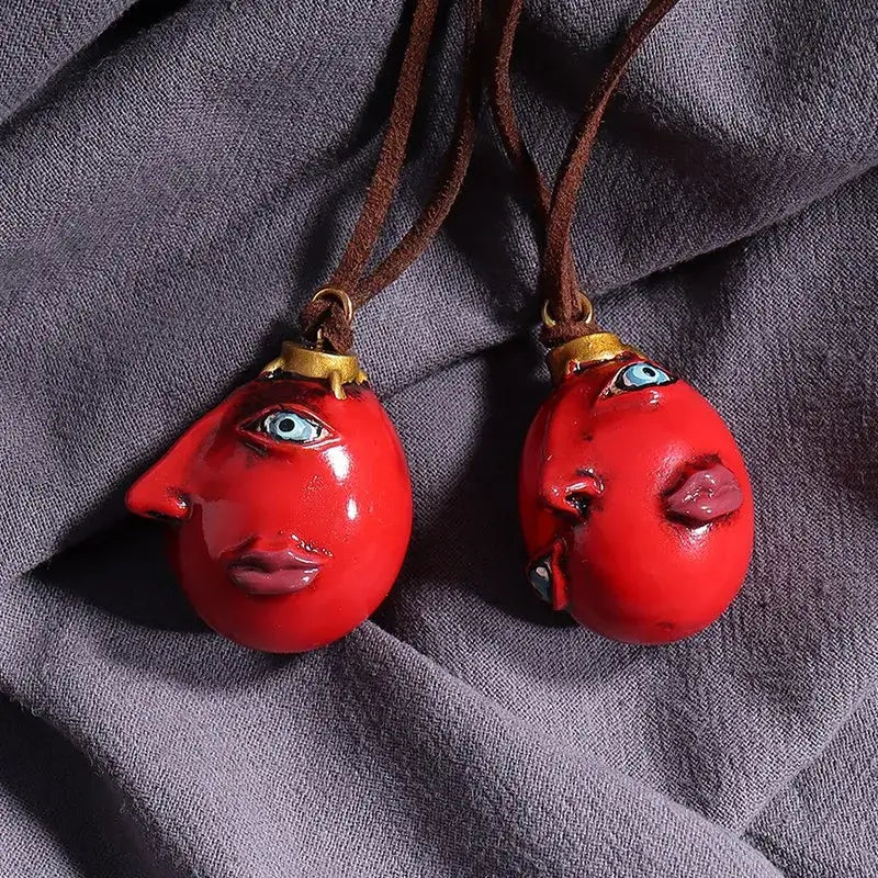 Berserk griffith behelit pendant resin necklace with two vibrant red glossy face-shaped resin pendants and blue painted details