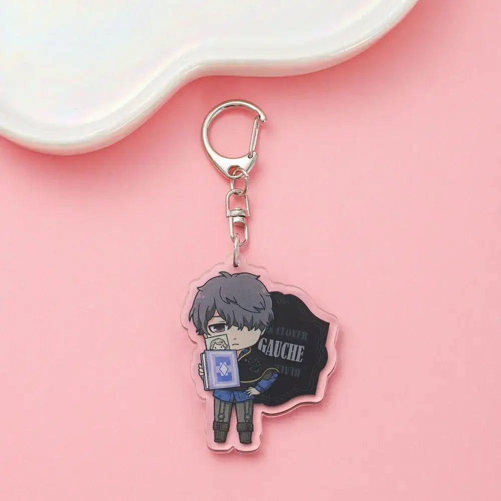 Clear acrylic black clover asta keychain featuring chibi anime character with gray hair holding book labeled gauche