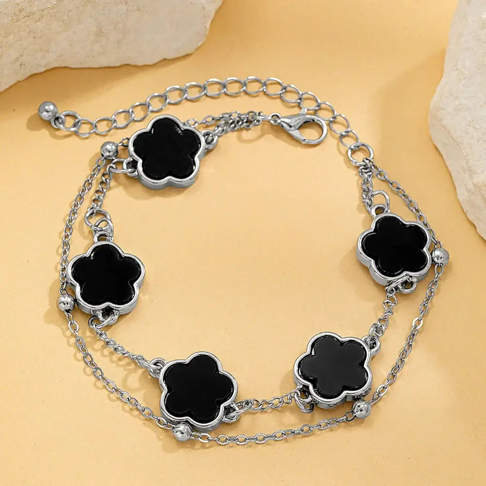Silver chain wrist chain featuring five black clover asta charms with polished metallic edges for stylish wear