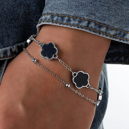 Silver chain wrist chain with two black clover asta charm featuring sleek modern five-leaf design