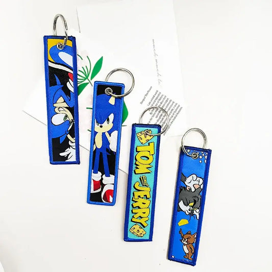 Blue embroidered leather key tag featuring black clover asta with sonic the hedgehog and tom & jerry characters