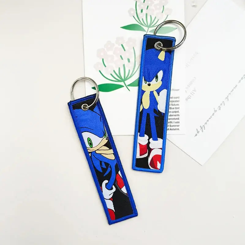 Blue embroidered sonic the hedgehog keychains with black and red accents paired with black clover asta leather key tag