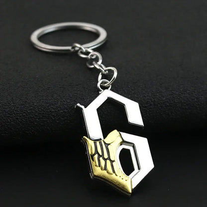 Silver and gold zinc alloy sword keychain featuring a stylized hexagonal s with an embossed skeletal hand design