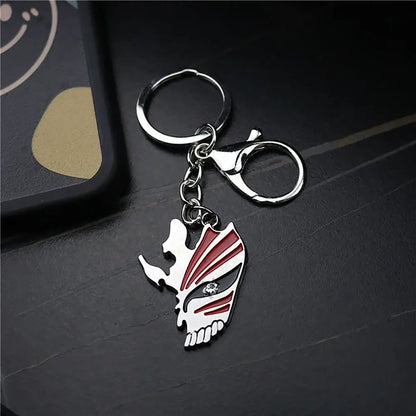 Silver and red enamel metal keychain with ichigo hollow mask design featuring black accents and a gemstone eye