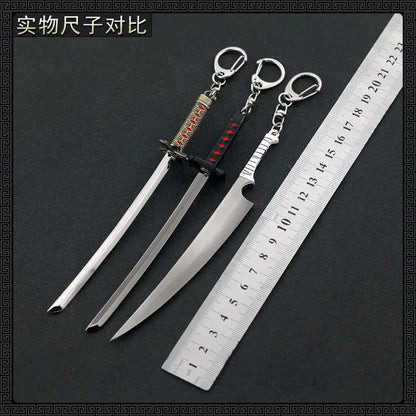 Metal ichigo hollow mask keychains shaped like swords with detailed hilts in red gold black and silver textured grip