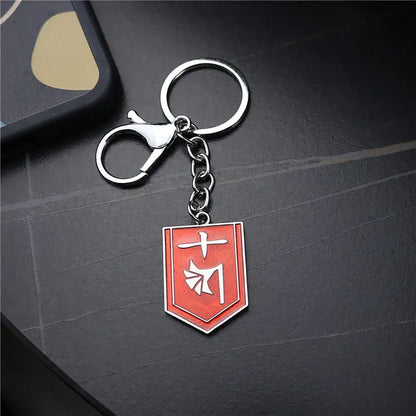 Red enamel metal ichigo hollow mask keychain with white japanese characters on shield shape and silver clasp