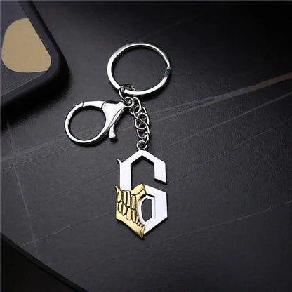 Silver and gold enamel metal keychain featuring a stylized s with skeletal hand design for ichigo hollow mask fans