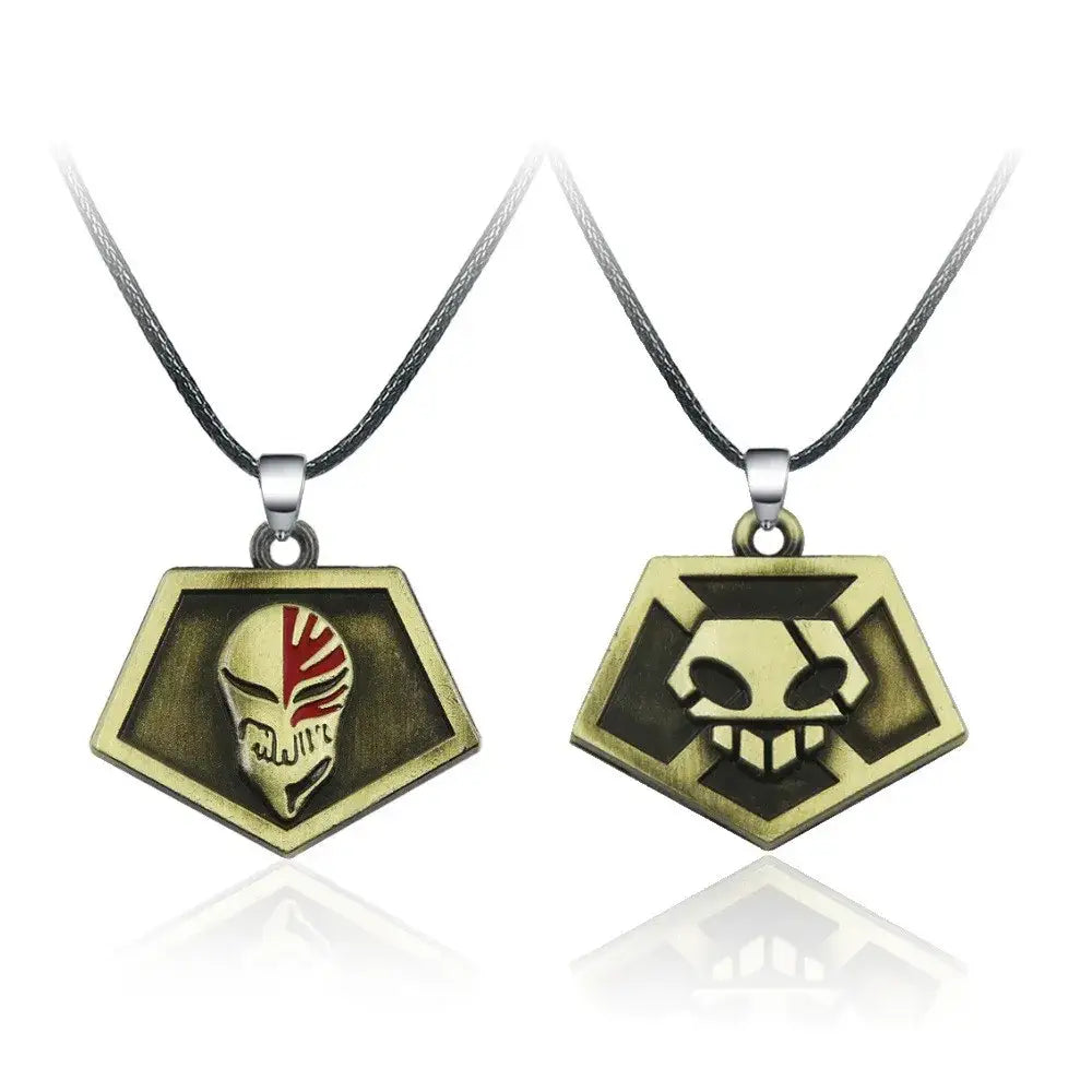 Two bronze-colored zinc alloy bleach ichigo mask necklaces with red-striped and sharp-toothed skull designs on black cords