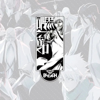 Black and white rectangular enamel pin of ichigo kurosaki with bold japanese kanji next to bleach acrylic stand figure 15cm