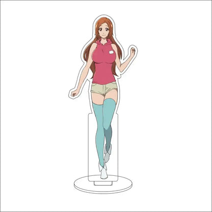 A clear acrylic stand figure of yuzu michiru from bleach with long orange hair wearing a pink hoodie and beige shorts