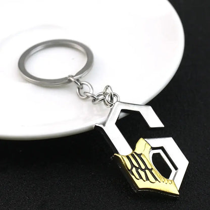 Silver and gold ulquiorra cifer metal pendant keychain featuring a stylized g with engraved skeletal hand design