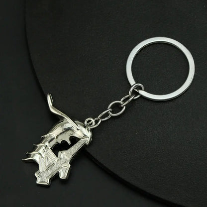 Silver metallic ulquiorra cifer mask keychain featuring a detailed stylized sword charm with angular textured design