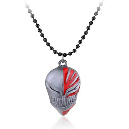 Silver and red enamel amulet necklace with detailed half-mask facial carvings on a zinc alloy chain