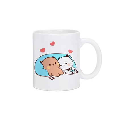 White ceramic bubu dudu panda bear christmas mug with cute cartoon animals cuddling on blue pillow with hearts