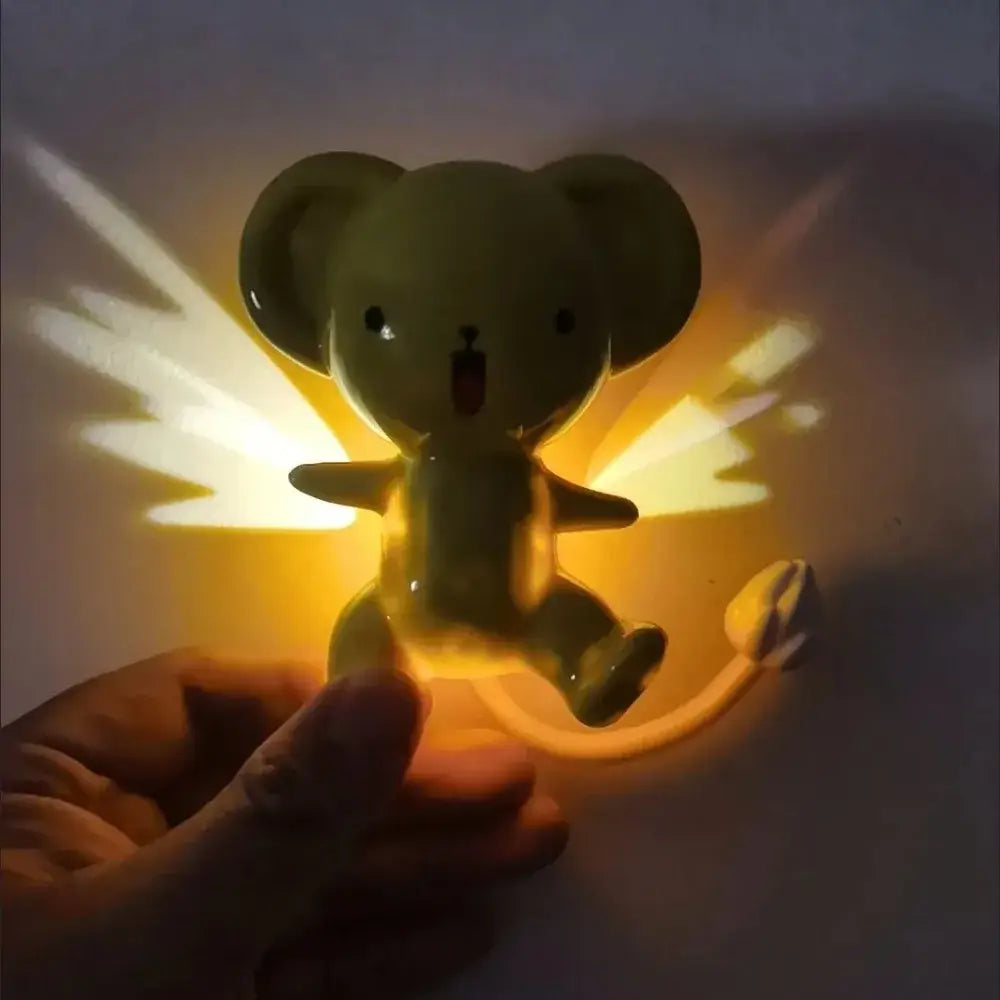 A glowing olive-green ceramic cardcaptor sakura cerberus mouse nightlight with wings and a surprised expression