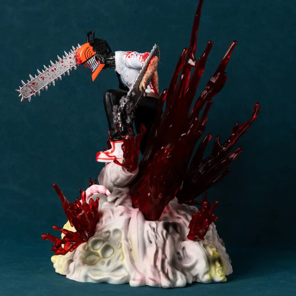 Detailed resin chainsaw man denji pvc statue wielding orange and black chainsaw in battle scene on textured white base