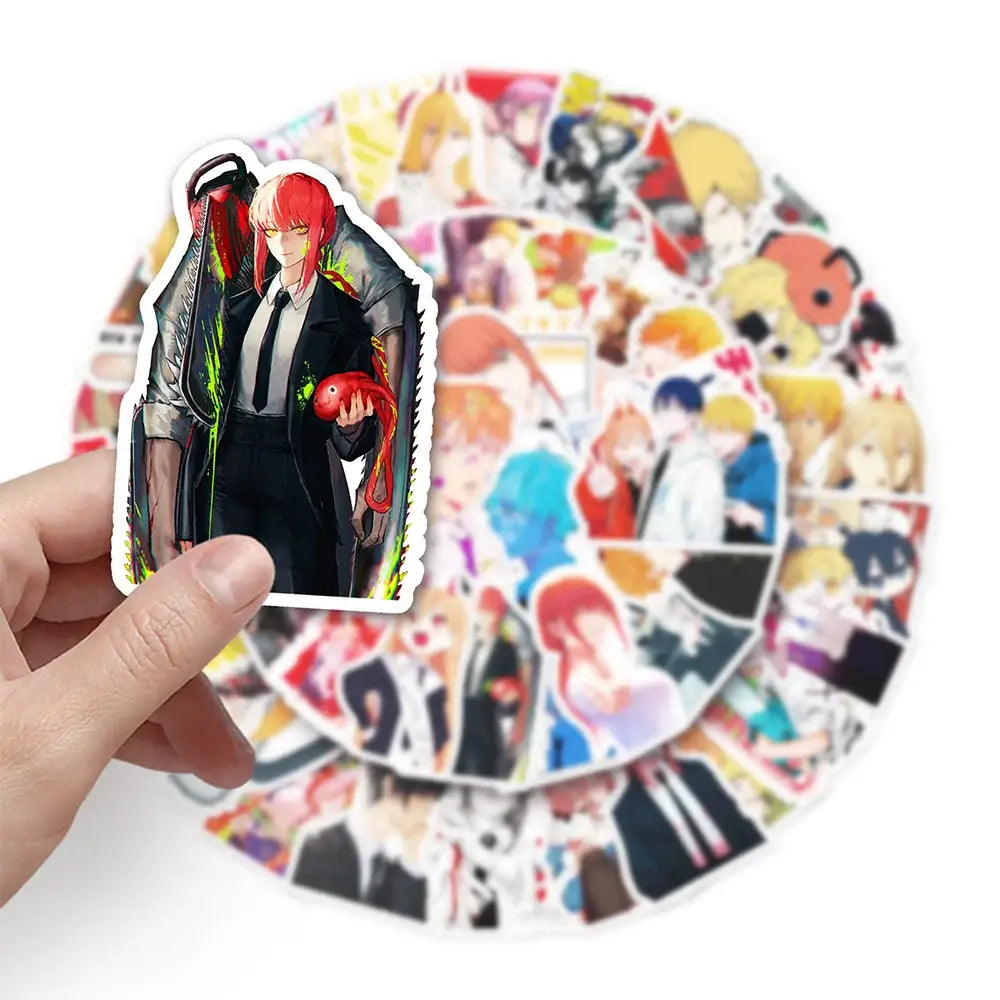 A hand holds a vibrant vinyl chainsaw man sticker set featuring denji with red hair and green glowing accents