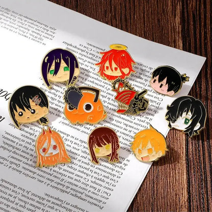 A collection of colorful glossy enamel pins featuring anime style chainsaw man character faces with varied expressions