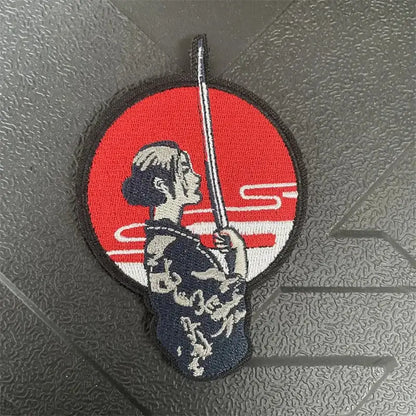 Circular chainsaw man power embroidery patch with hook-and-loop backing featuring a samurai on red background