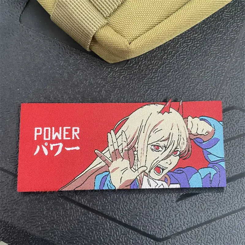 Red rectangular chainsaw man power embroidery patch with hook-and-loop backing featuring blonde anime character