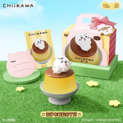 A cute white chiikawa figurine with rosy cheeks sits on a yellow pudding desk lamp for bedroom atmosphere light