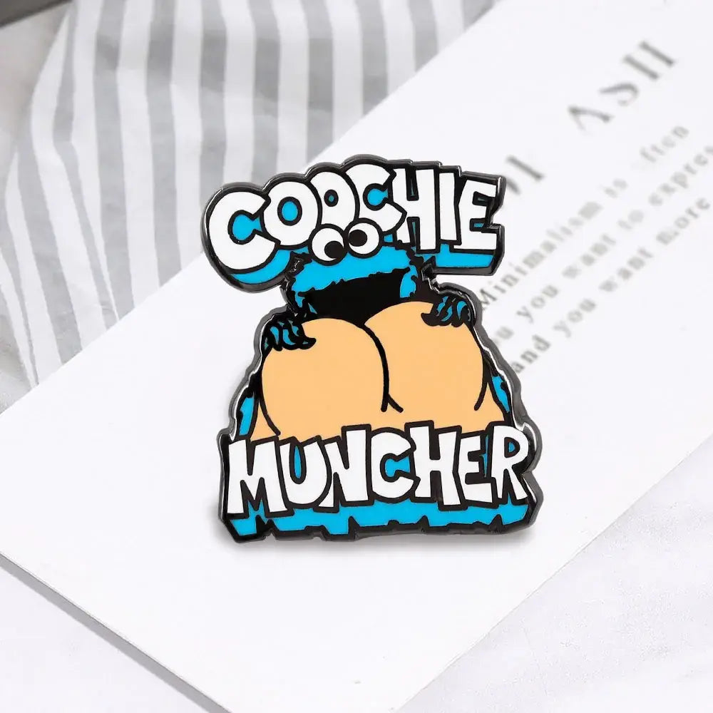 Blue and black cookie monster enamel pin cartoon brooch showing back holding cookie labeled coochie muncher