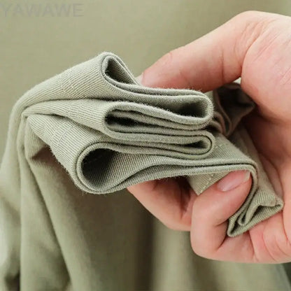 A hand holding a soft olive green ribbed knit fabric for a custom message unisex cotton o-neck t-shirt 4xl-5xl