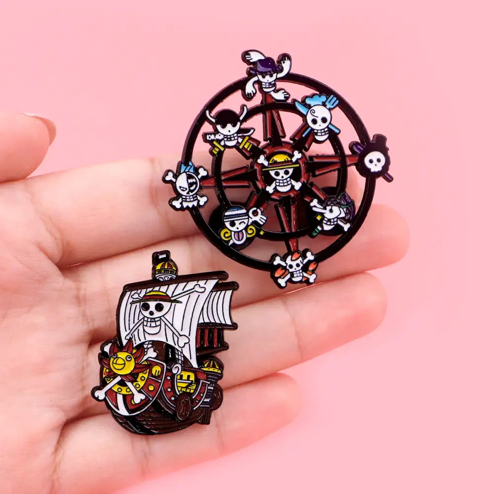 Set of two colorful metal enamel pins featuring one piece ship wheel and pirate ship in a cute enamel pin set