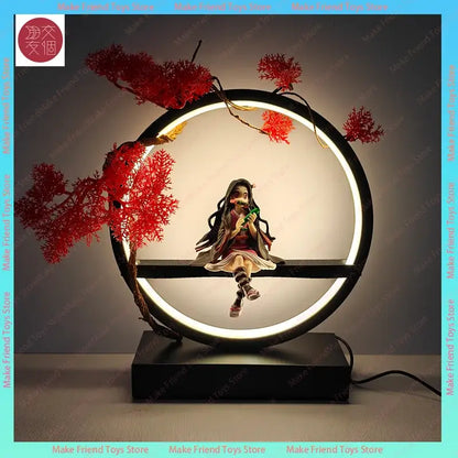 A black circular led night light with red coral-like branches and a seated nezuko anime figurine inside the illuminated ring
