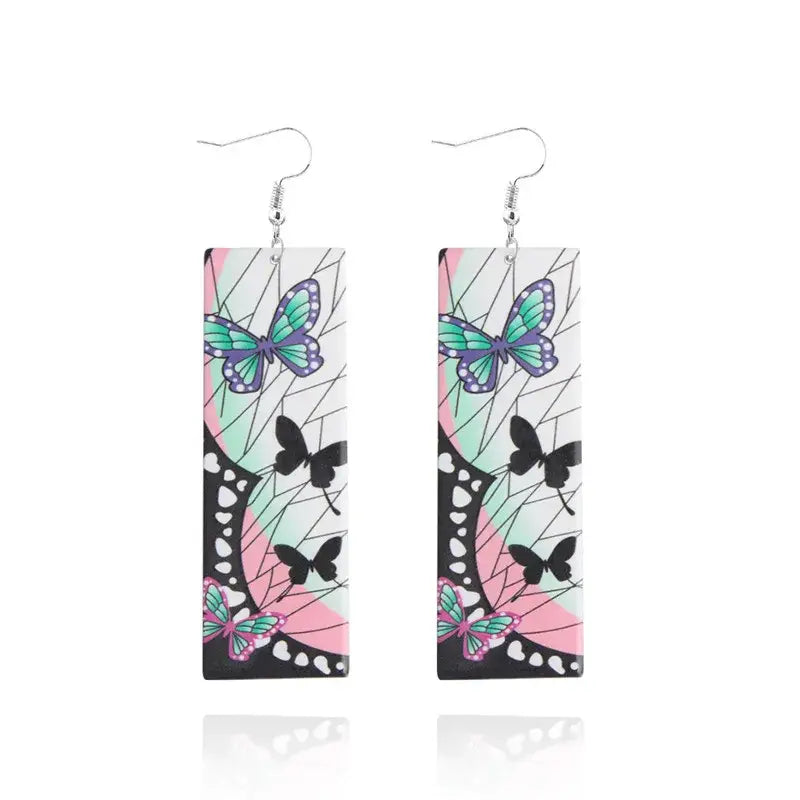 Rectangular demon slayer tanjiro butterfly drop earrings with teal and purple butterflies on white acrylic surface