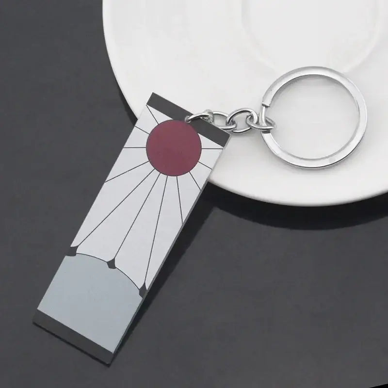 Silver demon slayer keychain with rectangular pendant featuring red sun emblem matching hanafuda earrings acrylic drop style