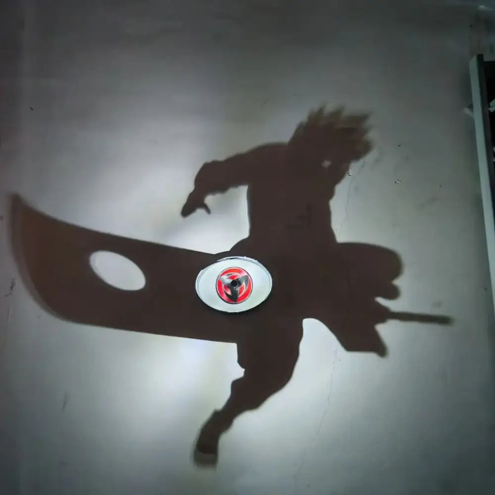 Shadow of detective conan goku character projected by led night light projector lamp on plain wall