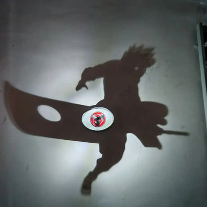 Shadow of detective conan goku character projected by led night light projector lamp on plain wall