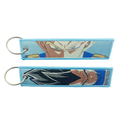 Two light blue embroidered dragon ball goku keychain holders with silver metal rings featuring anime characters