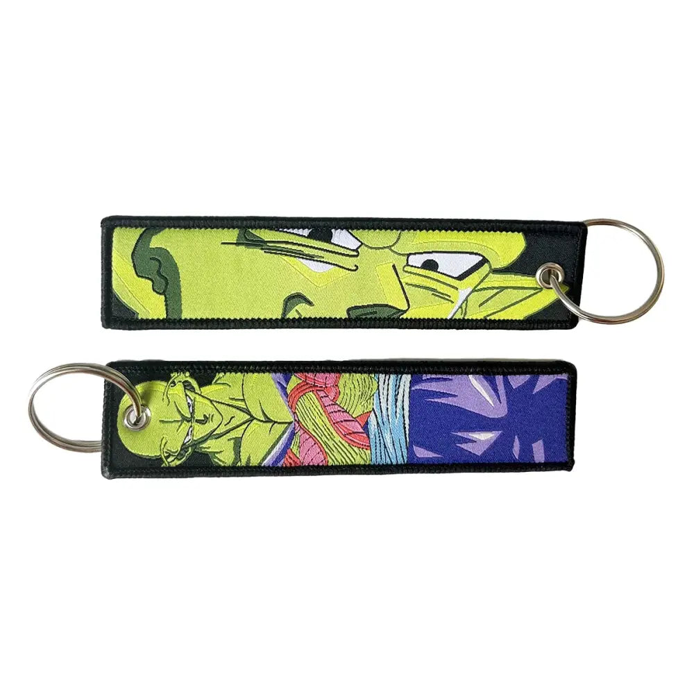 Two embroidered dragon ball goku keychain holders with vibrant anime fabric designs and black borders with metal rings