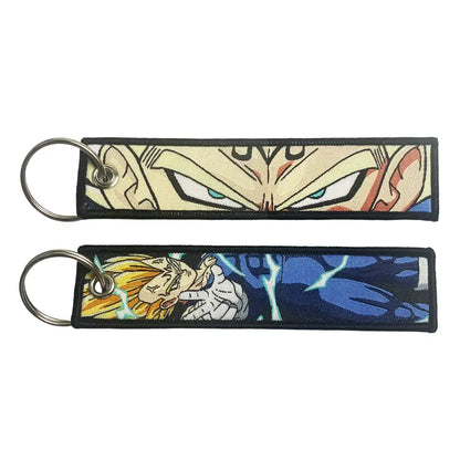 Two embroidered dragon ball keychain holders featuring dragon ball goku in beige blue and yellow hair action design