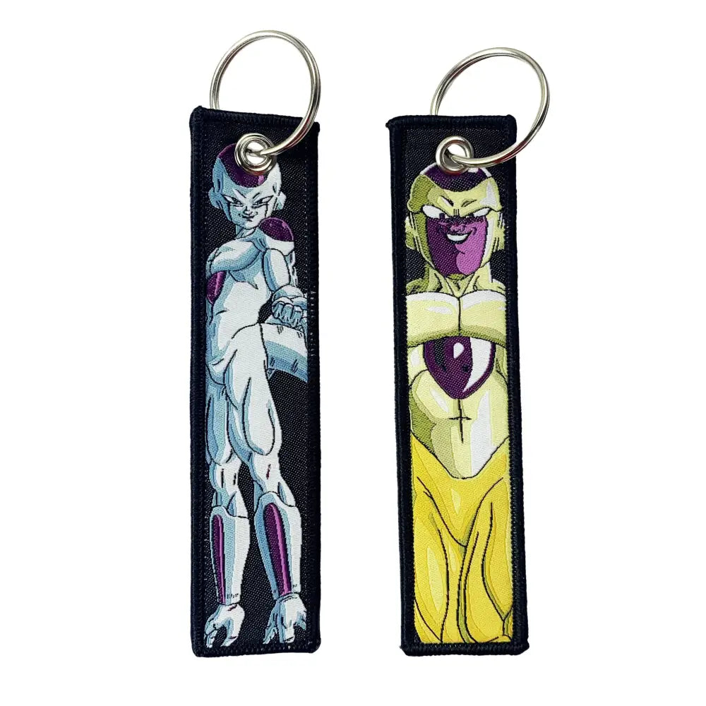 Two embroidered dragon ball goku keychain holders with white purple and yellow purple designs on silver metal rings