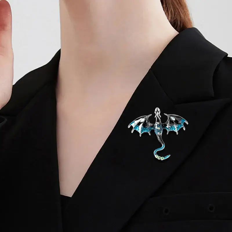 A sparkling blue and silver dragon colorful metal brooch lapel pin with intricate wing details and enamel finish